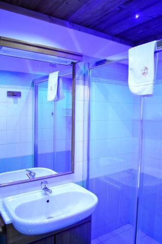a bathroom with a sink and a mirror and a tub at Hotel Chateau Blanc in La Thuile