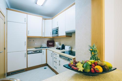 a kitchen with a bowl of fruit on a counter at Grand Muthu Forte do Vale in Albufeira