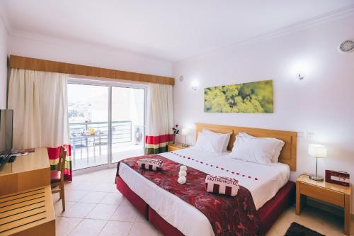 a hotel room with a bed and a balcony at Grand Muthu Forte do Vale in Albufeira