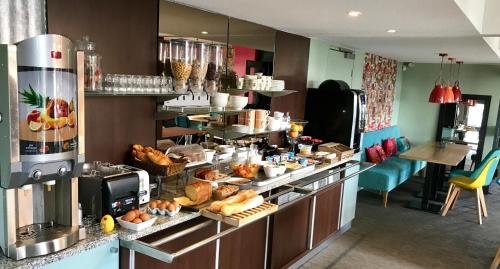 a kitchen with a counter with a bunch of food at Logis Boutique Hotel Novalis in Gradignan