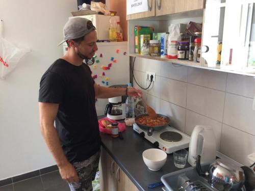 a man standing in a kitchen preparing food at Hostel Marina Trogir in Trogir