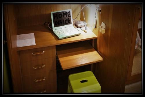 a laptop computer sitting on top of a wooden desk at HAPPY COLOURS in Old Town in Kecskemét