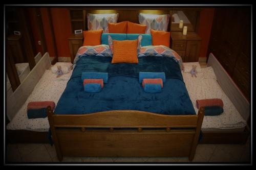 a bedroom with a blue bed with orange and blue pillows at HAPPY COLOURS in Old Town in Kecskemét