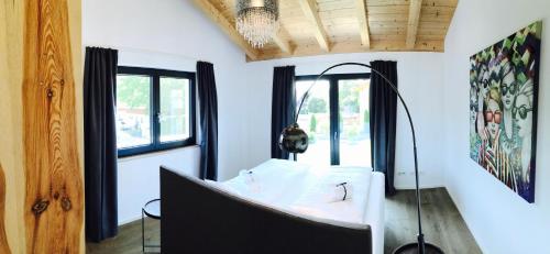 Zimmer mit einem Bett, einem Spiegel und Fenstern in der Unterkunft Ferienhaus Achmühle in Wolfratshausen