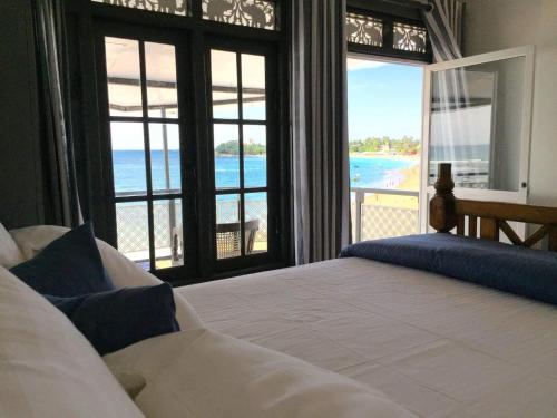 a bedroom with a bed and a view of the beach at Little Villa in Unawatuna