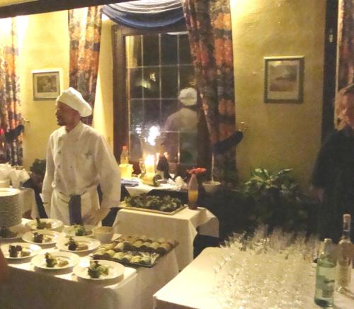 a chef standing in front of a table with food at Landhotel Zur alten Post in Lohr am Main