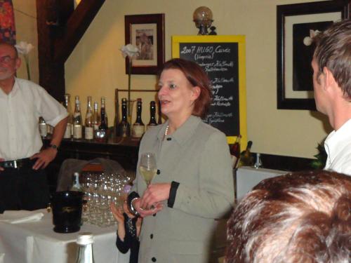 Eine Frau mit einem Glas Wein neben einem Barkeeper. in der Unterkunft Landhotel Zur alten Post in Lohr