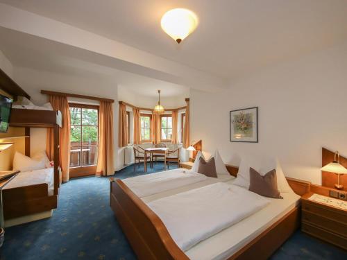 a hotel room with two beds and a table at Landgasthof Neuwirt in Lofer