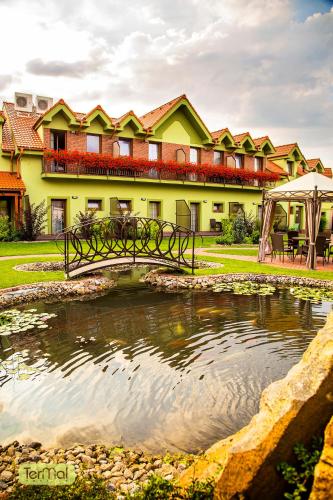 a bridge over a pond in front of a building at Penzion Termal in Bojnice