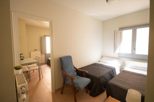a bedroom with two beds and a table and a chair at Center Plaza Figueres in Figueres
