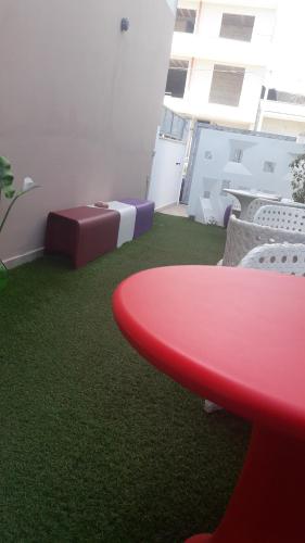 AradeoにあるCasa Fabiolaの緑のカーペット敷きの部屋(赤いテーブルと椅子付)