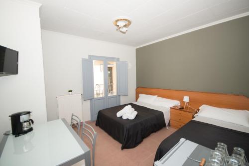 a bedroom with two beds and a table and a tv at Center Plaza Figueres in Figueres