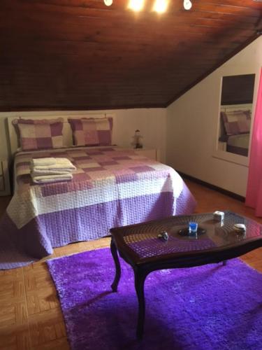 a bedroom with a bed and a purple rug at Casa da Avó in Geres