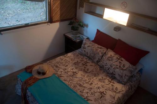 a bedroom with a bed with a hat on it at Hazyview Adventure Backpackers in Hazyview
