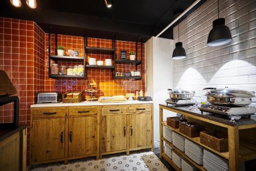 a kitchen with wooden cabinets and pots and pans at Leopold Hotel Ostend in Ostend