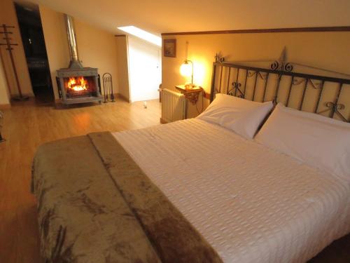 a bedroom with a large bed with a fireplace at Elai Etxea Loft Baias in Pobes