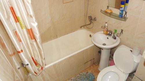a bathroom with a sink and a toilet and a bath tub at Apartments on Logvinenko 26a in Bishkek