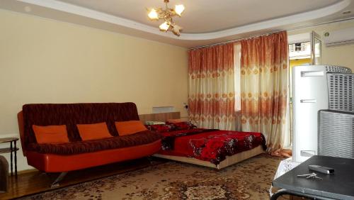 a living room with a bed and a chair at Apartments on Logvinenko 26a in Bishkek