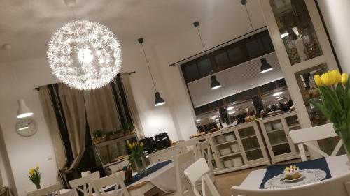 uma sala de jantar com uma mesa e cadeiras e um lustre em Dom Przy Plaży em Sarbinowo