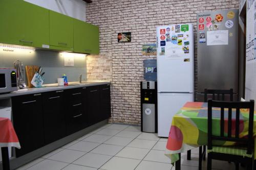 cocina con nevera y mesa. en Sky Hostel, en Yekaterinburg