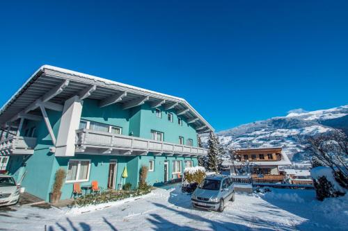 フューゲンにあるSonnseitn Appartementsの雪車付青い建物
