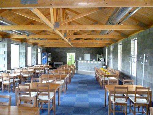 una sala da pranzo con tavoli e sedie in legno di Motel Dacice a Dačice