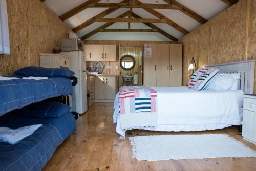 a bedroom with a white bed and a blue couch at Dibiki Holiday Resort in Hartenbos