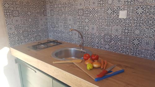 blat kuchenny ze zlewem i tablicą z warzywami w obiekcie Private Bay Residence w mieście Vrboska
