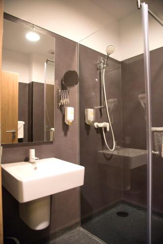 a bathroom with a sink and a shower at Hotel Lux Divina in Braşov