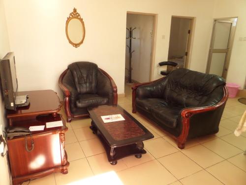 a living room with two leather chairs and a table at Sophia Hotel in Dar es Salaam