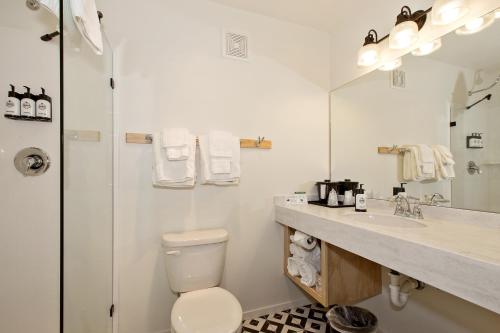 a white bathroom with a toilet and a sink at Sideways Inn in Buellton