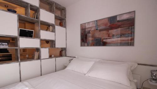 ミラノにあるItalianway-Bligny 39 Studioのベッドルーム1室(ベッド1台付)が備わります。壁には絵画が飾られています。
