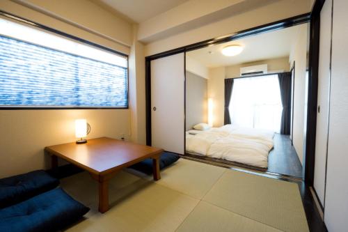 Habitación con cama, mesa y ventana en GOEN inn Tokyo, en Tokio