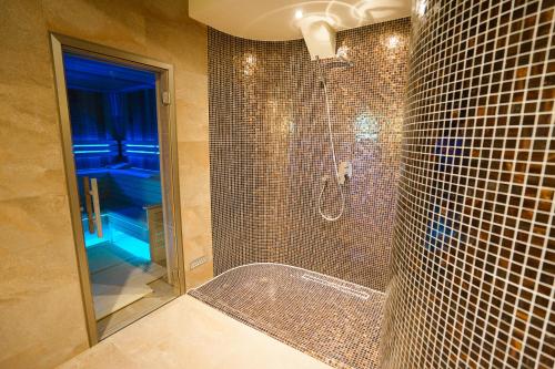 a bathroom with a shower with a glass door at Penzion Koráb in Prague