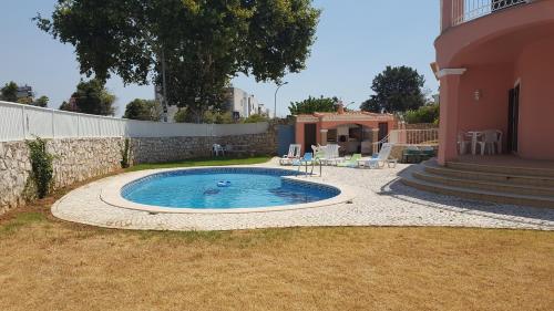 a swimming pool in a yard next to a house at Saraiva's Guest House in Lagos