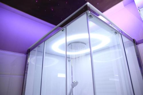 a bathroom with a shower with purple lighting at Starry Sky Charming House in Alghero