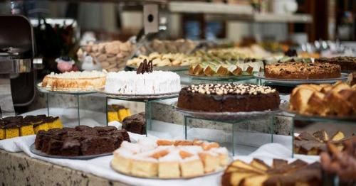 eine Ausstellung verschiedener Kuchen- und Gebäcksorten in der Unterkunft Pousada Cantina Italiana in Nova Trento