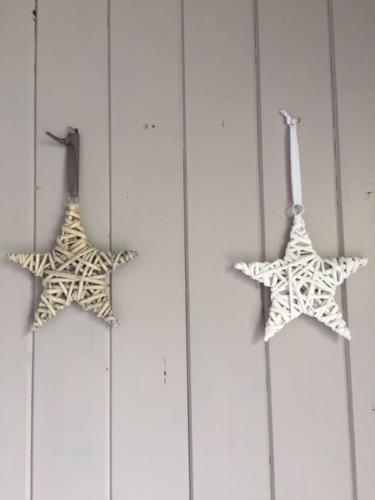 three star decorations hanging on a white wall at La Maison de Lilly in Arcachon