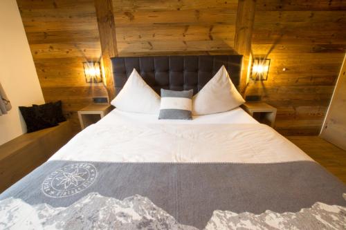 a bedroom with a large bed with wooden walls at Bodenhof Ferienwohnungen in Fieberbrunn