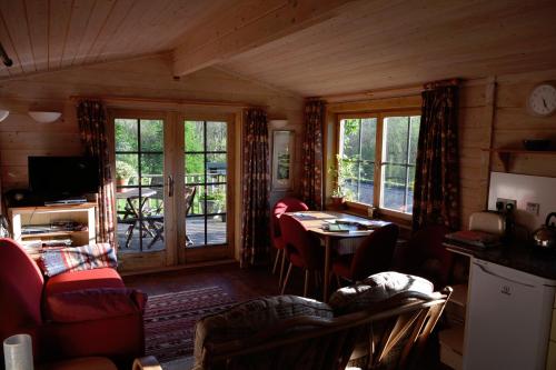 a living room with a table and chairs at Log Cabin in Brecon