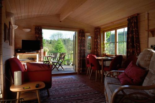 sala de estar con sofá y mesa en Log Cabin, en Brecon