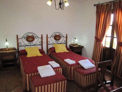 two twin beds in a room with a window at Hotel Cortijo Las Grullas in Benalup Casas Viejas