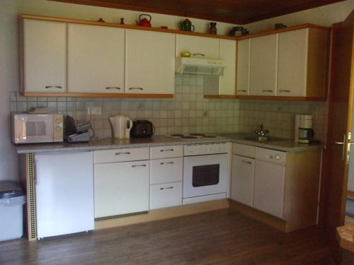 a kitchen with white cabinets and white appliances at Bloserhof Hauser in Zellberg