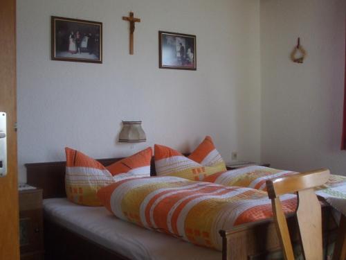 a bedroom with a bed with pillows and a cross on the wall at Bloserhof Hauser in Zellberg