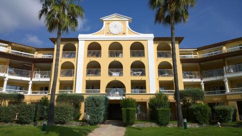 un edificio giallo con una torre dell'orologio sopra di Les Rivages des Issambres a Les Issambres
