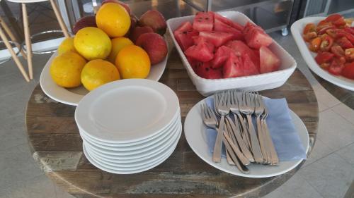 una mesa con platos y tazones de fruta. en Marica's Boutique Hotel, en Pafos
