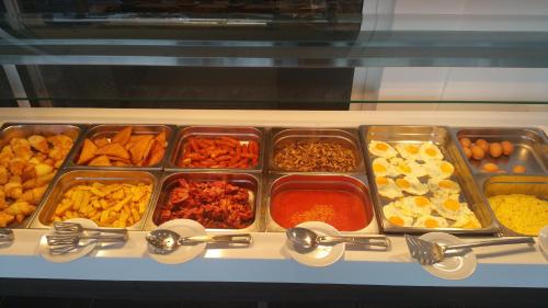 una vitrina con bandejas de diferentes tipos de alimentos en Marica's Boutique Hotel, en Pafos