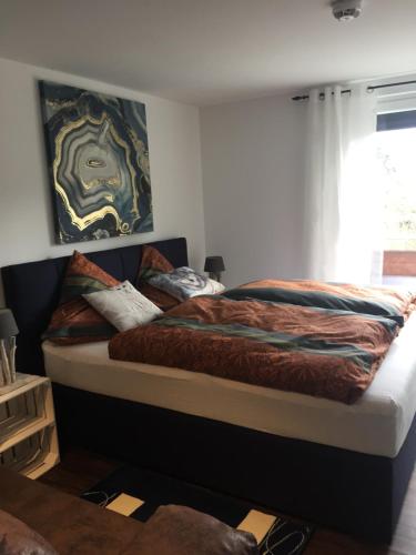 Un dormitorio con una cama grande con un cuadro en la pared. en Tami's Harzglück, en Braunlage