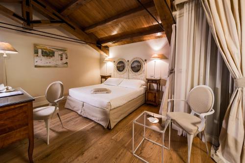 a bedroom with a bed and a desk and chairs at Hotel & Residenza 100 Torri in Ascoli Piceno