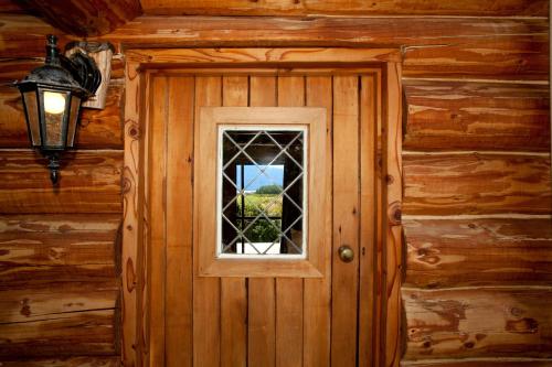 a door with a window in a log cabin at Fiordland Lodge in Te Anau